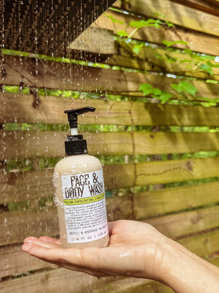 An upright view of the Exfoliating Face and Body Wash bottle from Apotheke DuJardin, featuring a sleek, lowercase front panel layout.